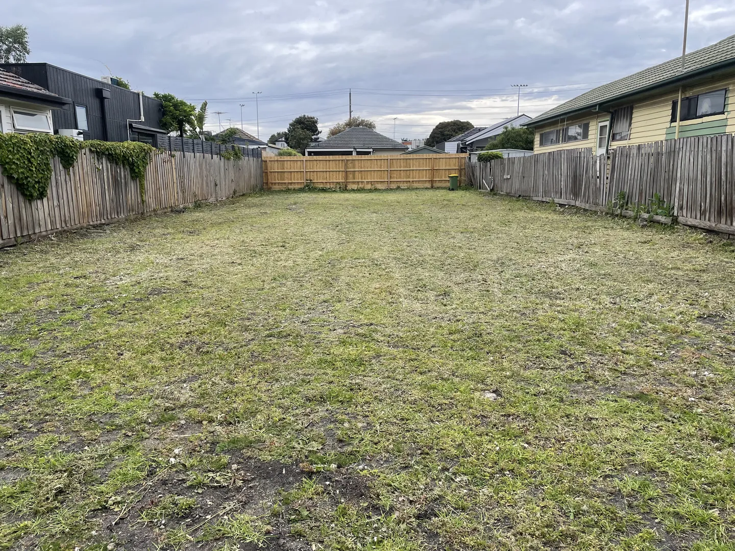 Spacious residential vacant lawn neatly mown short by lawn mowing service